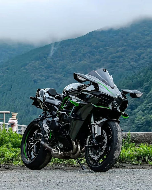 Motorcycle parked on a road with mountains in the background