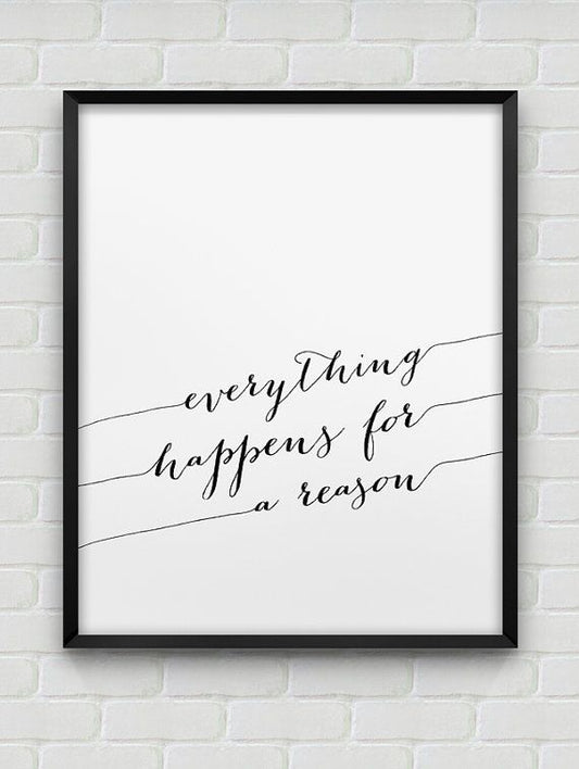 Framed print with 'everything happens for a reason' text on a white brick wall.