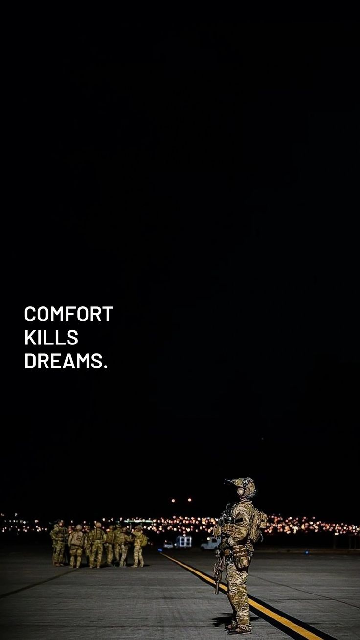 Soldiers in camouflage standing on a runway with a dark sky and text 'COMFORT KILLS DREAMS'.