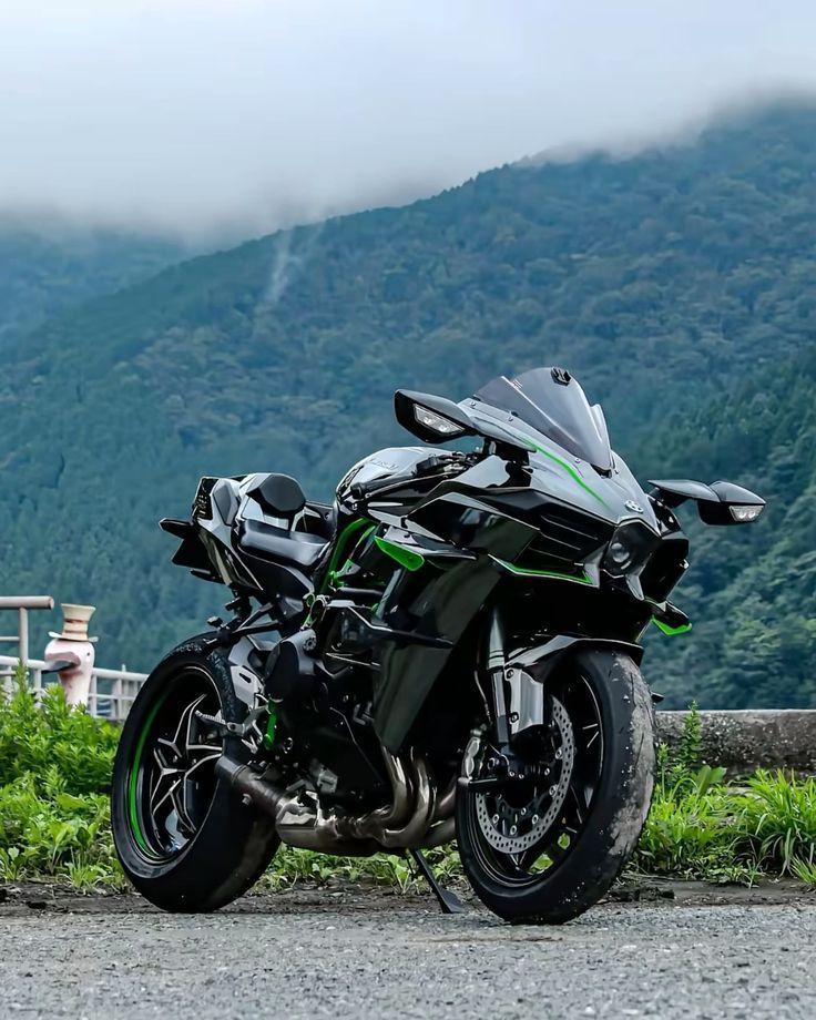 Motorcycle parked on a road with mountains in the background