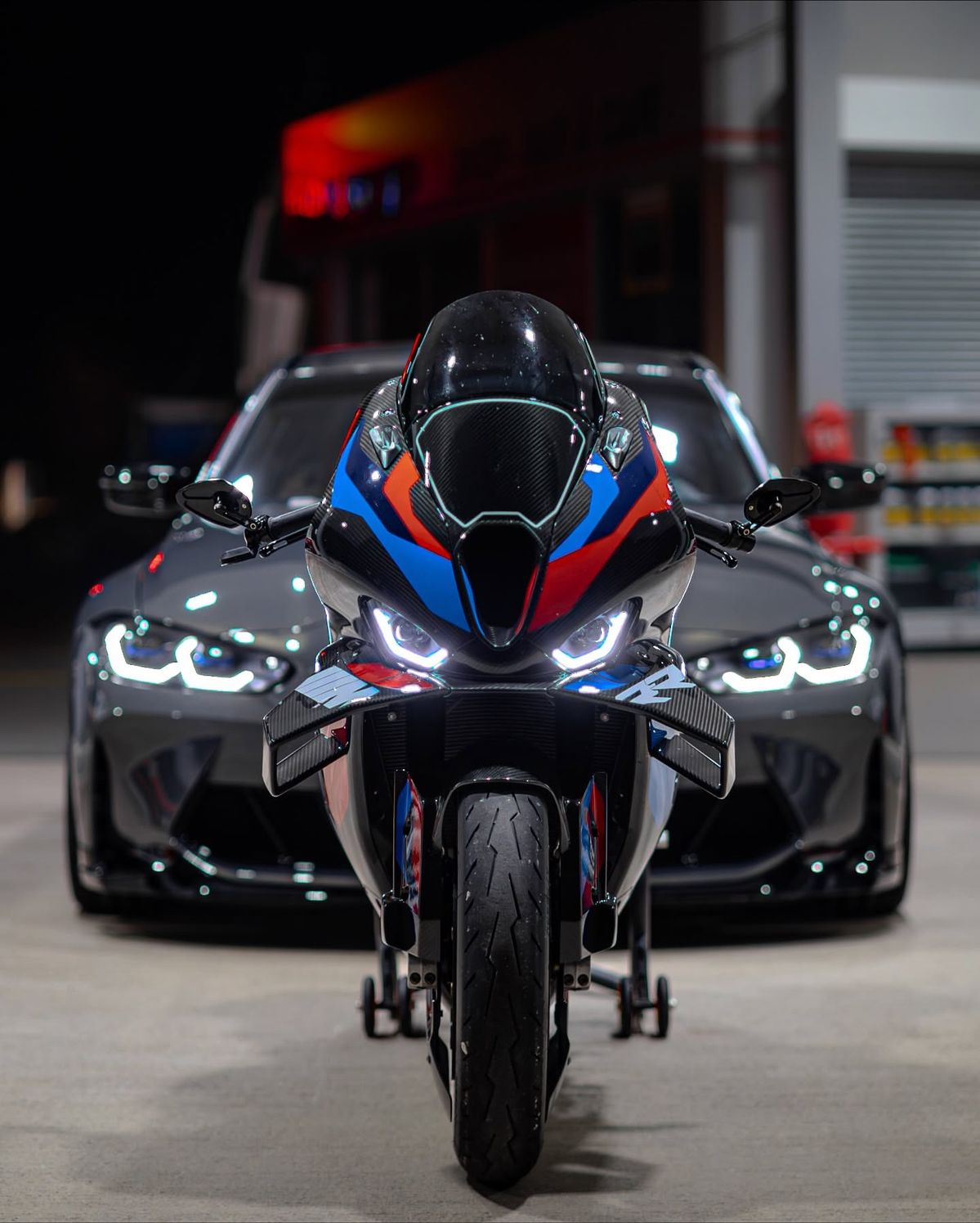Motorcycle with a car in the background in a garage setting