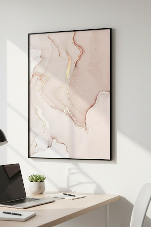 Abstract art print on a wall above a desk with a laptop and lamp.