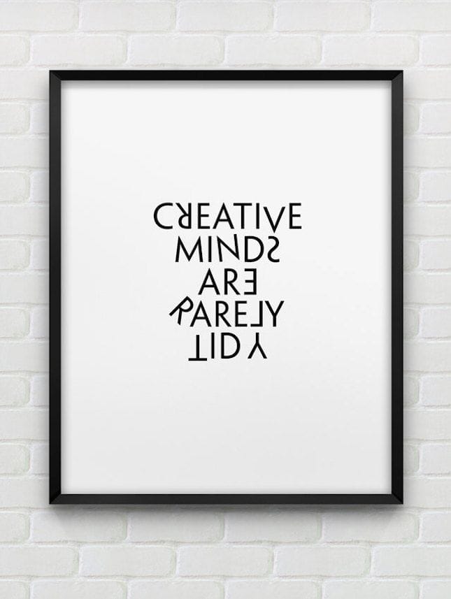 Framed poster with 'CREATIVE MINDS ARE RARELY LID' text on a white brick wall background
