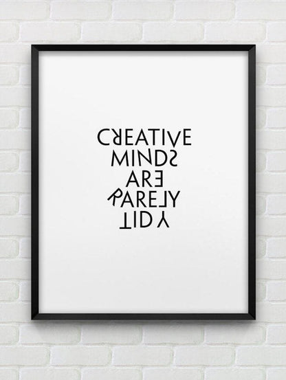 Framed poster with 'CREATIVE MINDS ARE RARELY LID' text on a white brick wall background