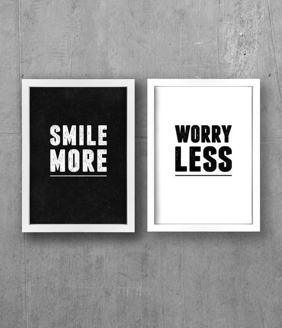 Two framed prints with motivational phrases 'Smile More' and 'Worry Less' on a concrete wall.